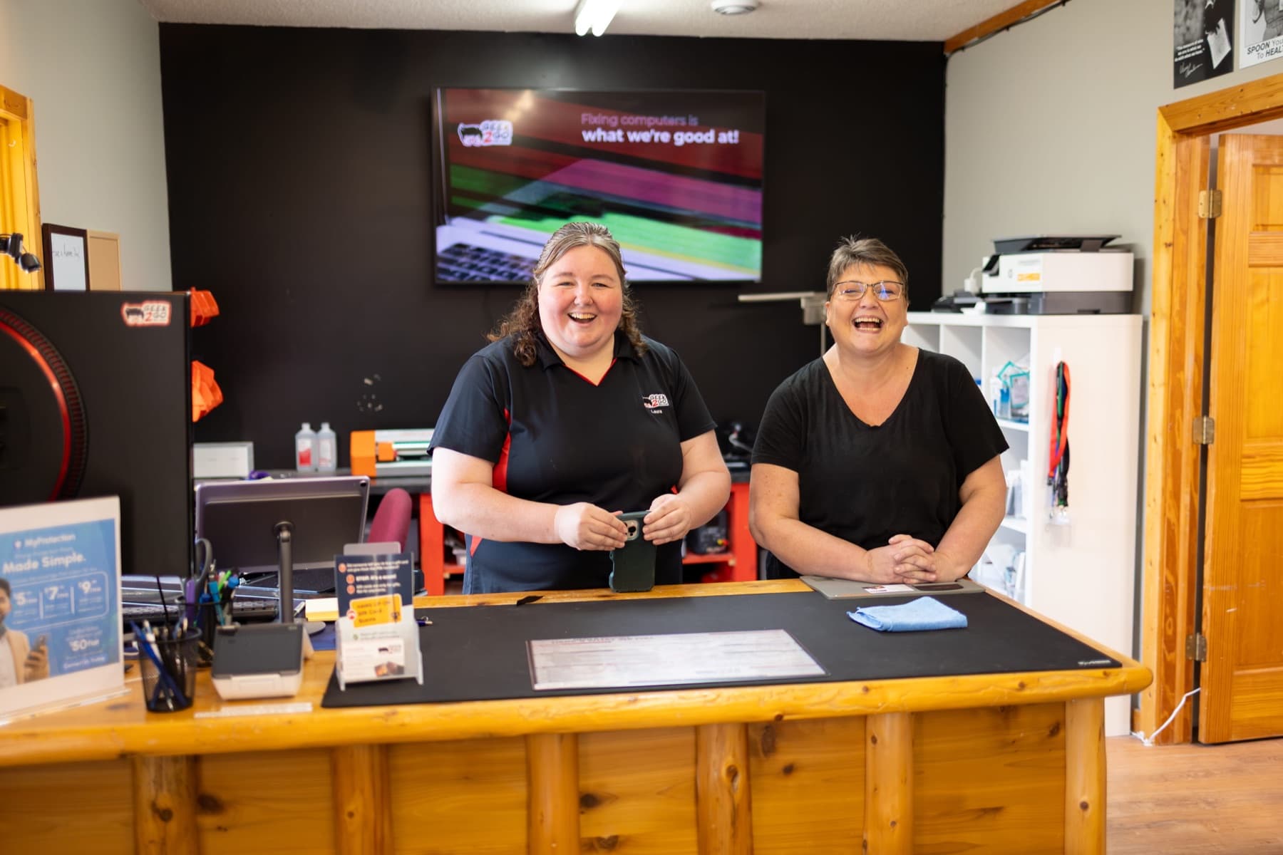 Geek2Go staff smiling at the repair counter